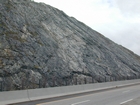 I 26 Tn-NC border road cut exposing a mix of metamorphosed sedimentary rocks intruded by granite.  The ages and names of the units involved may determined from local roadside maps of the geology