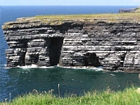 The Ross Formation of Loop Head is here expressed as turbidite sheet sands that accumulated as deepwater fan lobes that were dissected by sparse shallowly incised channels. As Elliot (2000) records these are the thicker bedded, high net-to-gross, sheet turbidites of the lower part of the Ross Sandstone Formation turbidite system. The height of these cliffs is between 45-50 m. Note the shaley partings that may compartmentalize these sands and seperate them in terms of their reservoir quality from those above. Shallow though the channeling may be it may enhance vertical reservoir continuity between the stacked sheets