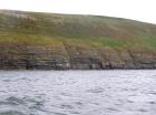 Rehy Cliffs exposing two channelled amalgamated deepwater fills, offset from each other. The lower channel is just above present sea level, highlighted by gull droppings. Ross Sandstone probably in mid fan position towards center of fan body.